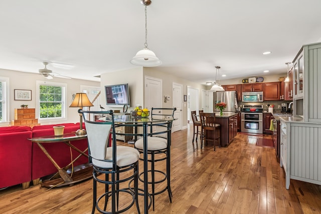 3 Bradfield Way, Kennebunk, ME 04043 - kitchen featuring appliances with stainless steel finishes, light wood-style floors, a center island, ceiling fan, and hanging light fixtures