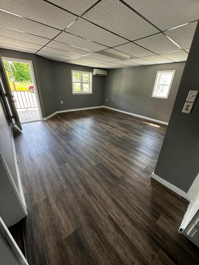 6 Main St, Howland, ME 04448 - spare room featuring an AC wall unit, baseboards, a paneled ceiling, dark wood finished floors, and healthy amount of natural light