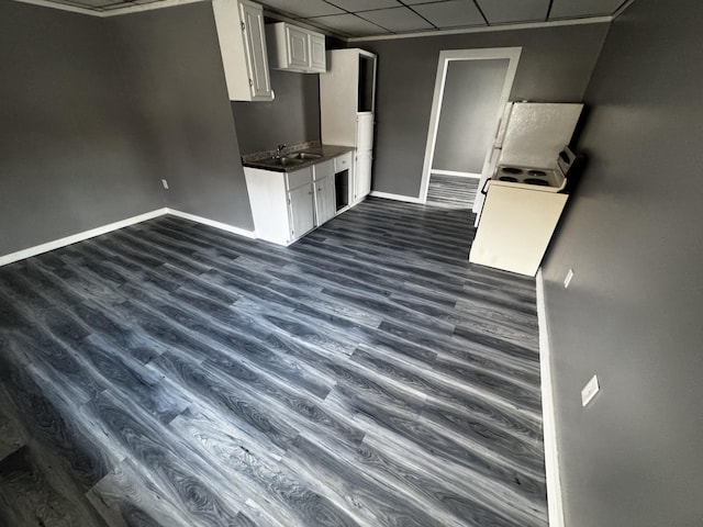 6 Main St, Howland, ME 04448 - kitchen with a drop ceiling, dark countertops, baseboards, dark wood-style floors, and white cabinets
