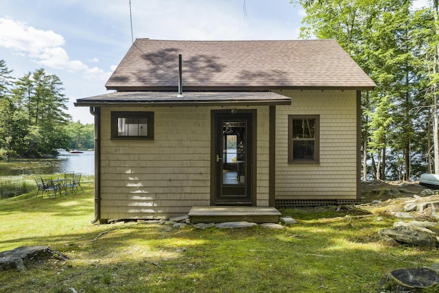 36 Cove Ln, Damariscotta, ME 04543 - rear view of property featuring a shingled roof, a yard, and a water view