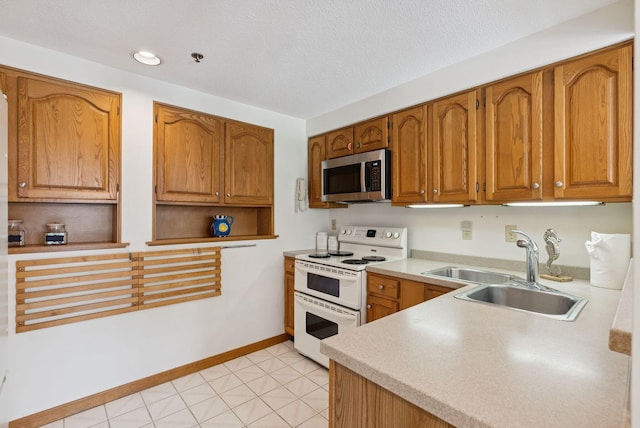44 Meadowbrook Dr Unit 4, Gorham, ME 04038 - kitchen with stainless steel microwave, range with two ovens, a sink, brown cabinets, and light countertops