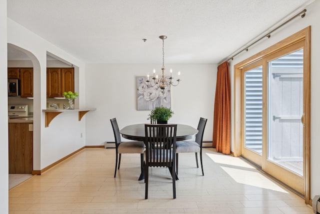 44 Meadowbrook Dr Unit 4, Gorham, ME 04038 - dining room with a chandelier, light wood finished floors, a textured ceiling, arched walkways, and a baseboard heating unit