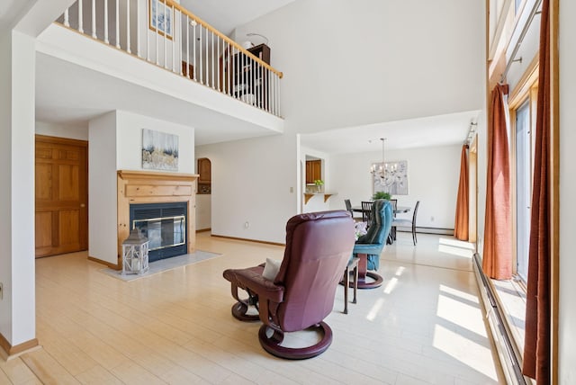 44 Meadowbrook Dr Unit 4, Gorham, ME 04038 - living room with a towering ceiling, healthy amount of natural light, a glass covered fireplace, and baseboards