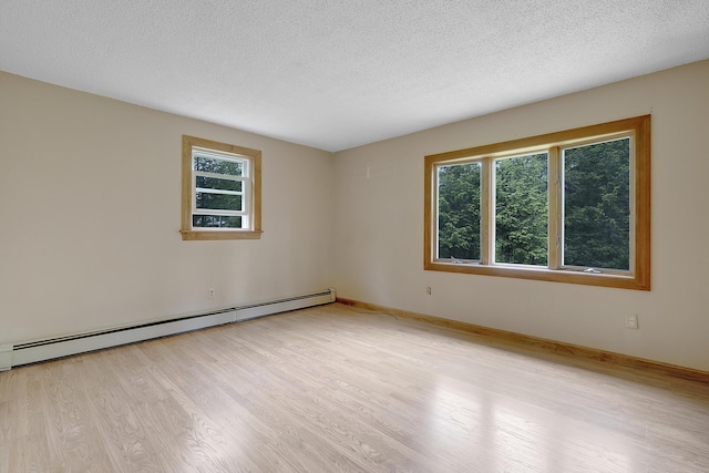 31 W Bay Bridge Rd, Topsham, ME 04086 - unfurnished room featuring a baseboard heating unit, healthy amount of natural light, light wood finished floors, and a textured ceiling