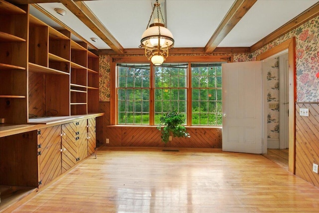 1835 Main St, Fayette, ME 04349 - unfurnished dining area featuring healthy amount of natural light, light wood-style flooring, wallpapered walls, beamed ceiling, and wooden walls