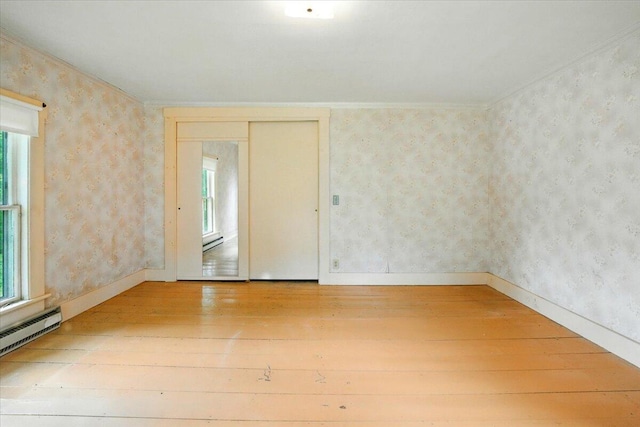 1835 Main St, Fayette, ME 04349 - empty room with hardwood / wood-style flooring, plenty of natural light, wallpapered walls, a baseboard radiator, and ornamental molding