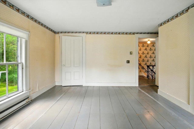 1835 Main St, Fayette, ME 04349 - empty room with wallpapered walls, baseboard heating, healthy amount of natural light, and hardwood / wood-style flooring
