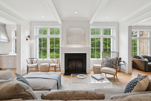38 Fieldstone Ln, Falmouth, ME 04105 - living room featuring healthy amount of natural light, light wood-style flooring, a fireplace with flush hearth, ornamental molding, and beam ceiling