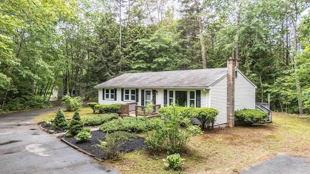 70 Whitten Rd, Kennebunk, ME 04043 - ranch-style house with a chimney, a porch, and a wooded view