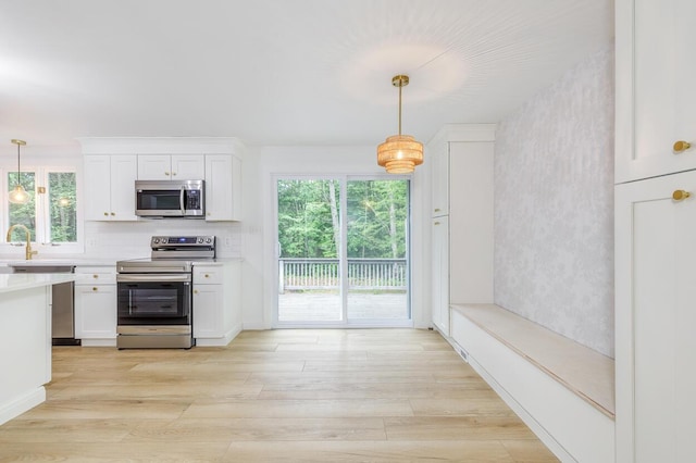70 Whitten Rd, Kennebunk, ME 04043 - kitchen featuring stainless steel appliances, healthy amount of natural light, white cabinetry, and light countertops