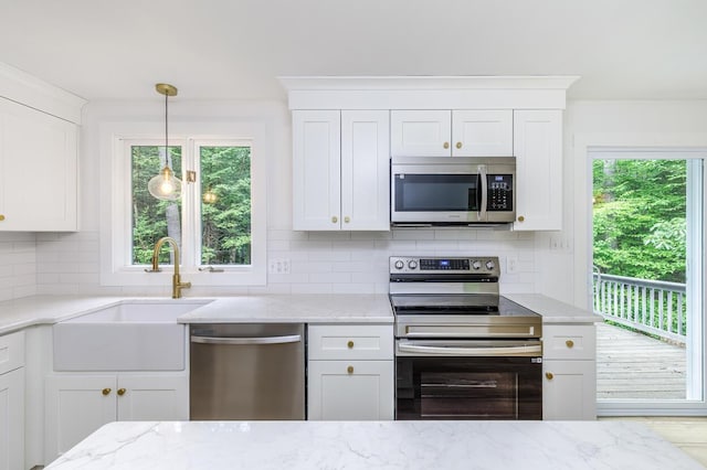 70 Whitten Rd, Kennebunk, ME 04043 - kitchen with stainless steel appliances, tasteful backsplash, and healthy amount of natural light