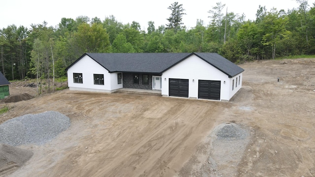316 Clark Rd, Hermon, ME 04401 - view of front facade with dirt driveway, an attached garage, and a wooded view