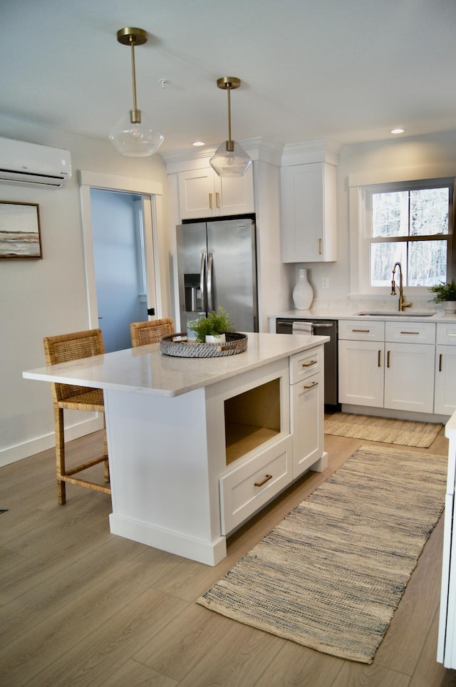 14 Salt Point Dr Unit 19, Old Orchard Beach, ME 04064 - kitchen featuring stainless steel appliances, a wall mounted AC, a sink, white cabinets, and light countertops