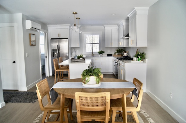 14 Salt Point Dr Unit 19, Old Orchard Beach, ME 04064 - kitchen with appliances with stainless steel finishes, a wall unit AC, wood finished floors, white cabinetry, and baseboards