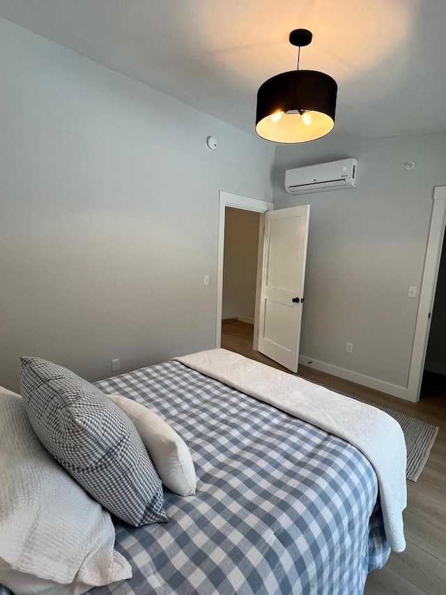 14 Salt Point Dr Unit 19, Old Orchard Beach, ME 04064 - bedroom with an AC wall unit, wood finished floors, and baseboards