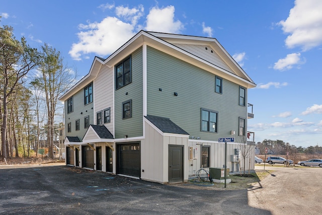 14 Salt Point Dr Unit 19, Old Orchard Beach, ME 04064 - view of side of home featuring an attached garage, driveway, and board and batten siding