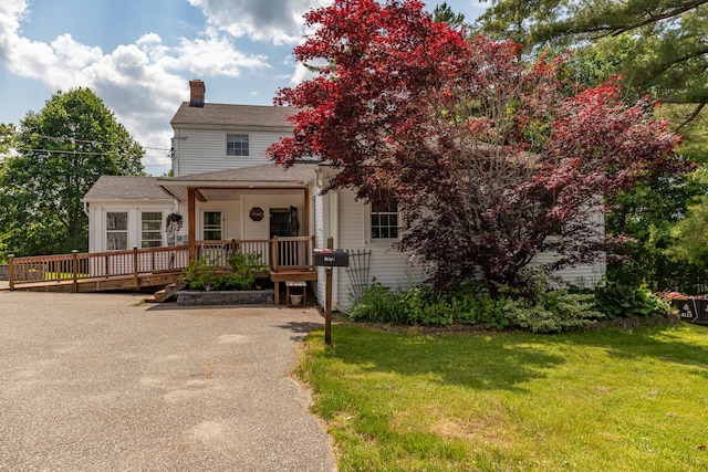 166 Franklin St, Bucksport, ME 04416 - obstructed view of property featuring a chimney, a wooden deck, a front lawn, and roof with shingles
