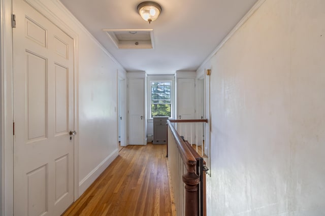 166 Franklin St, Bucksport, ME 04416 - hallway with an upstairs landing, light wood finished floors, attic access, and crown molding