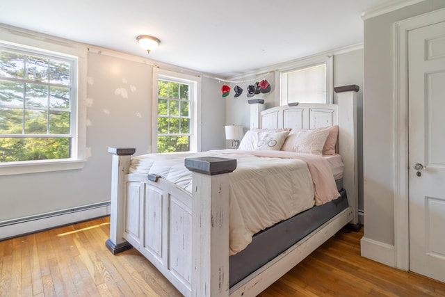 166 Franklin St, Bucksport, ME 04416 - bedroom with light wood finished floors, baseboard heating, and ornamental molding
