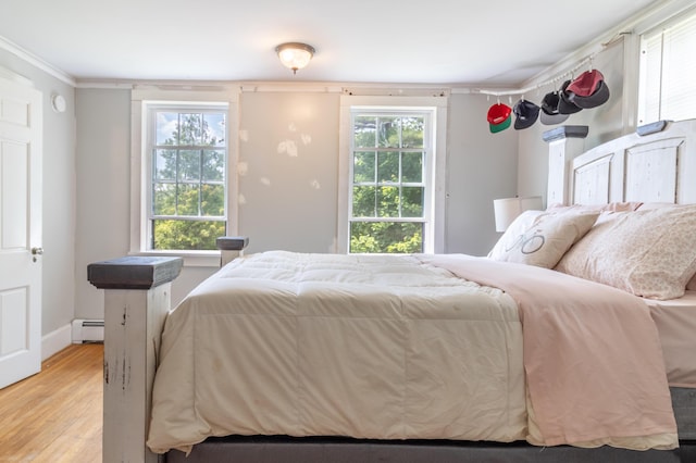 166 Franklin St, Bucksport, ME 04416 - bedroom featuring a baseboard heating unit, light wood finished floors, and crown molding