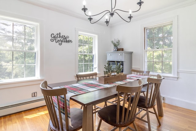 166 Franklin St, Bucksport, ME 04416 - dining space with a chandelier, light wood-type flooring, crown molding, a baseboard radiator, and a glass covered fireplace