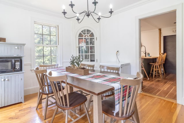 166 Franklin St, Bucksport, ME 04416 - dining room with a chandelier, light wood-type flooring, and crown molding