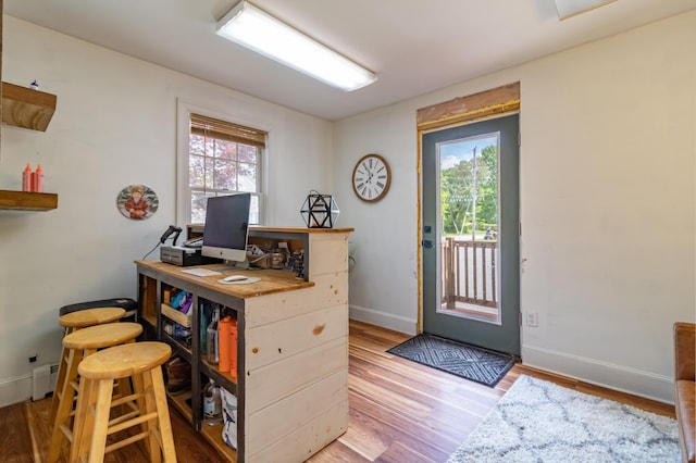 166 Franklin St, Bucksport, ME 04416 - home office featuring plenty of natural light, wood finished floors, and a baseboard radiator
