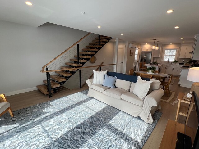 20 Salt Point Dr Unit 22, Old Orchard Beach, ME 04064 - living room featuring wood finished floors, recessed lighting, stairs, and a wall mounted air conditioner