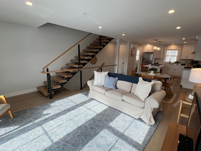 22 Salt Point Dr Unit 23, Old Orchard Beach, ME 04064 - living room with wood finished floors, recessed lighting, stairs, a wall mounted AC, and baseboards