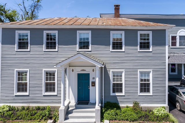 19 Mason St, Brunswick, ME 04011 - view of front facade with a standing seam roof, a chimney, and metal roof