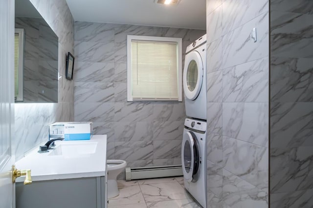19 Mason St, Brunswick, ME 04011 - laundry area with a baseboard heating unit, stacked washer and clothes dryer, and light marble finish floors