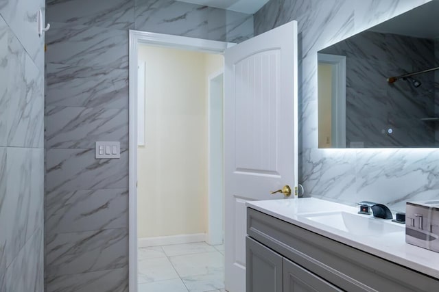 19 Mason St, Brunswick, ME 04011 - bathroom featuring vanity, marble finish floors, baseboards, decorative backsplash, and a shower