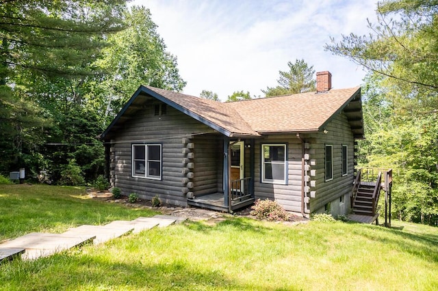 1103 Rte 135, Monmouth, ME 04259 - log-style house with log siding, a chimney, a front yard, and a shingled roof
