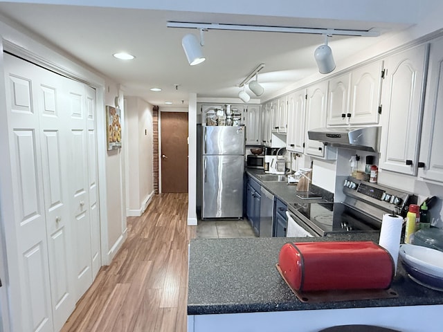 245 Broadway Unit 106, South Portland, ME 04106 - kitchen featuring appliances with stainless steel finishes, under cabinet range hood, dark countertops, light wood finished floors, and recessed lighting