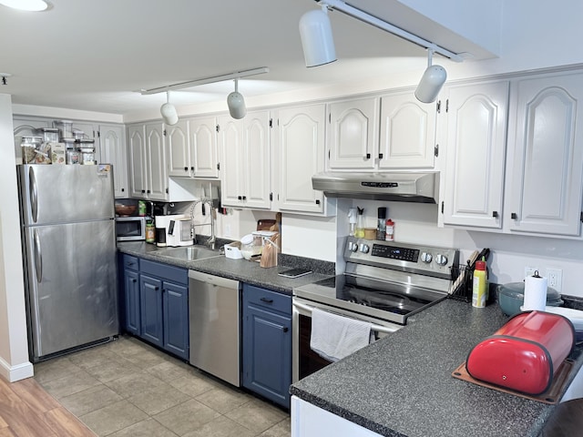 245 Broadway Unit 106, South Portland, ME 04106 - kitchen featuring stainless steel appliances, blue cabinetry, rail lighting, and under cabinet range hood