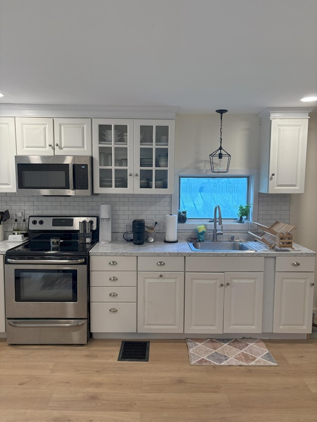 10 Valley St, Augusta, ME 04330 - kitchen with appliances with stainless steel finishes, a sink, decorative backsplash, and white cabinetry