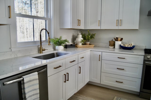 26 Salt Point Dr Unit 25, Old Orchard Beach, ME 04064 - kitchen featuring appliances with stainless steel finishes, a sink, white cabinetry, light stone countertops, and light wood-style floors
