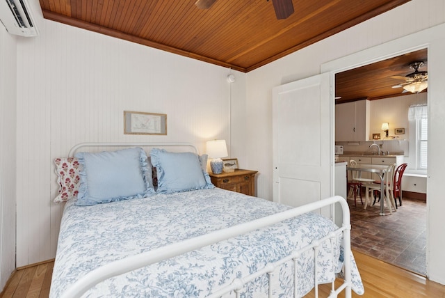134 W Grand Ave, Old Orchard Beach, ME 04064 - bedroom with a wall mounted air conditioner, wood ceiling, ornamental molding, wood finished floors, and wooden walls