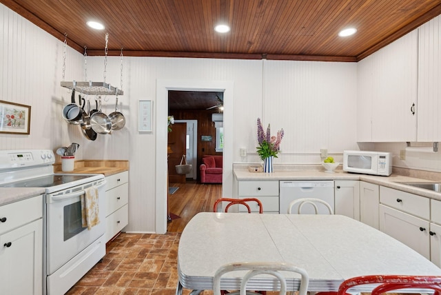 134 W Grand Ave, Old Orchard Beach, ME 04064 - kitchen with white appliances, wood ceiling, white cabinets, light countertops, and wooden walls