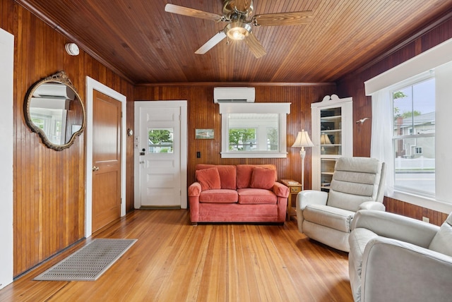 134 W Grand Ave, Old Orchard Beach, ME 04064 - living area featuring a wall unit AC, wood walls, wooden ceiling, light wood-style flooring, and a ceiling fan
