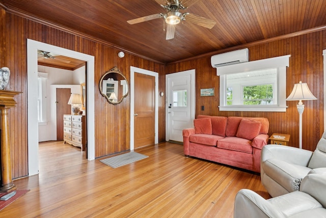 134 W Grand Ave, Old Orchard Beach, ME 04064 - living area featuring a ceiling fan, a wall mounted AC, wooden walls, crown molding, and light wood finished floors