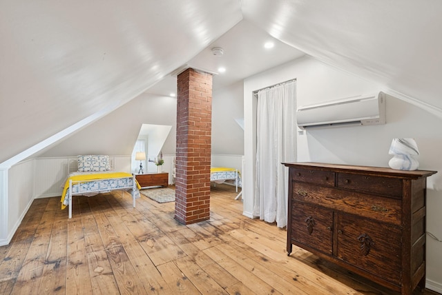 134 W Grand Ave, Old Orchard Beach, ME 04064 - bedroom featuring decorative columns, a wall mounted air conditioner, lofted ceiling, and hardwood / wood-style flooring