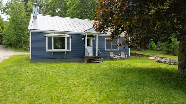 188 Old Chadbourne Rd, Lewiston, ME 04240 - view of front of house with a front yard, a chimney, entry steps, and metal roof