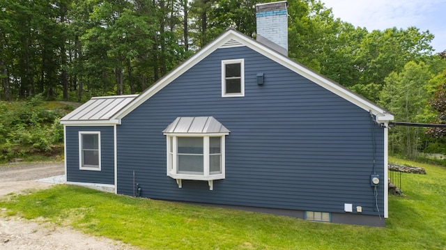 188 Old Chadbourne Rd, Lewiston, ME 04240 - view of property exterior featuring a standing seam roof, a yard, a chimney, and metal roof