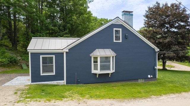188 Old Chadbourne Rd, Lewiston, ME 04240 - view of home's exterior with a chimney, metal roof, a lawn, and a standing seam roof