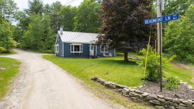 188 Old Chadbourne Rd, Lewiston, ME 04240 - view of front facade with a chimney, a front yard, metal roof, dirt driveway, and a standing seam roof