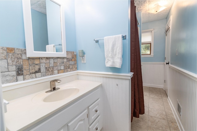 188 Old Chadbourne Rd, Lewiston, ME 04240 - bathroom featuring wainscoting, vanity, and decorative backsplash