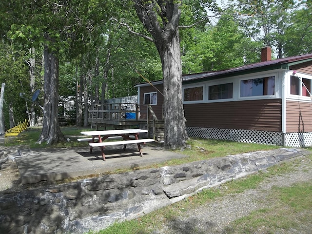 41 Hickory Ln, Alexander, ME 04694 - exterior space with a chimney, a deck, and a patio