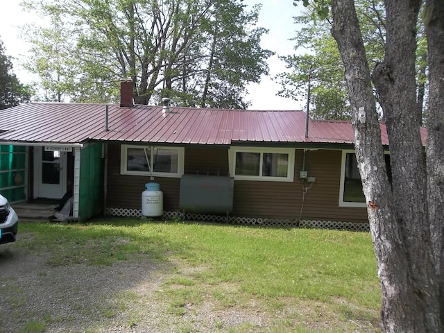 41 Hickory Ln, Alexander, ME 04694 - view of front of home featuring oil tank, a front yard, a chimney, and metal roof