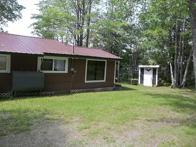 41 Hickory Ln, Alexander, ME 04694 - view of home's exterior with heating fuel, a yard, and metal roof
